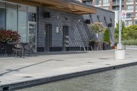 the exterior of a restaurant and water features potted flowers near a pool in front