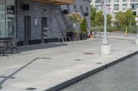 the exterior of a restaurant and water features potted flowers near a pool in front