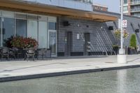 the exterior of a restaurant and water features potted flowers near a pool in front