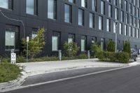 a parked car on a paved street in front of black buildings and a parking space