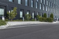 a parked car on a paved street in front of black buildings and a parking space