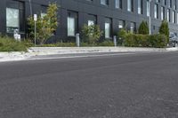 a parked car on a paved street in front of black buildings and a parking space