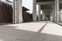 an empty sidewalk with a long metal fence near the stairs to a building in the background