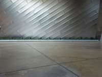 the front side of a large modern building with metallic siding and a light shining on it