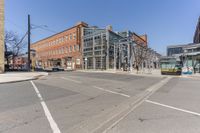 two buildings are built next to the city streets and some cars have stopped at the corner