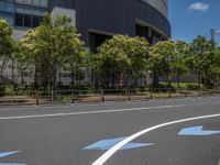 empty road with white lines on the streets of city area against cloudy blue sky on a sunny day