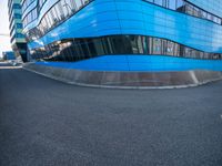 an empty parking lot with modern buildings on a sunny day, blue sky is reflected in the building's glass windows