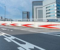 an intersection in a city with cars on the road and red painted arrows all over the pavement