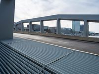 a view of a city street through metal grate grids on a building ramp