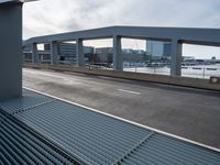 a view of a city street through metal grate grids on a building ramp