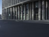 a large tall building sitting on the side of a road between two buildings of different sizes