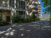 a paved brick street with red trash bins sitting in the middle and trees near to it