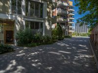 a paved brick street with red trash bins sitting in the middle and trees near to it