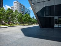 a city sidewalk with a building in the background and trees around it in the foreground