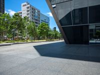 a city sidewalk with a building in the background and trees around it in the foreground