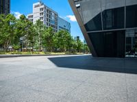 a city sidewalk with a building in the background and trees around it in the foreground