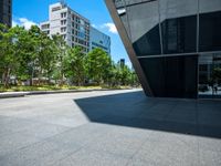 a city sidewalk with a building in the background and trees around it in the foreground