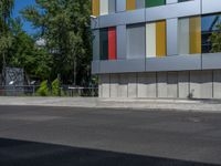 a fire hydrant sitting outside a colorful building next to a green tree line of trees