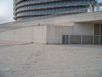 a black fire hydrant is sitting in the concrete area in front of a large building