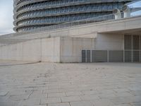 a black fire hydrant is sitting in the concrete area in front of a large building