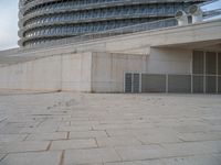 a black fire hydrant is sitting in the concrete area in front of a large building