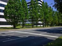 street view of city buildings and trees in front of the road, seen from across an empty street