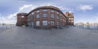 a fisheye image of an empty skateboard park with the building at the rear