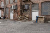 the warehouse is empty, with crates outside it and an open air conditioner next to the garage