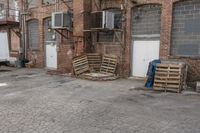 the warehouse is empty, with crates outside it and an open air conditioner next to the garage