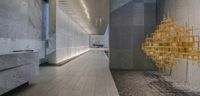 the modern looking hallway features gold decorations on each wall and a brick walkway with no cars,