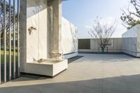 the courtyard features many concretes and greenery, including a concrete fountain and trees and trees around