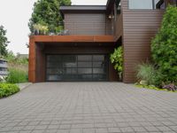 there is an outside view of a house with brown exterior and wooden building, plants around the entrance area and trees