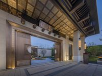 a wooden door leads to the outdoor area of a home in asia and the outside has a large mirror