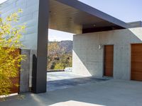 a gray concrete building with stairs and door at the top of the floor next to it is steps leading down to the doorway