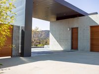 a gray concrete building with stairs and door at the top of the floor next to it is steps leading down to the doorway