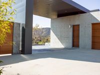 a gray concrete building with stairs and door at the top of the floor next to it is steps leading down to the doorway