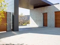 a gray concrete building with stairs and door at the top of the floor next to it is steps leading down to the doorway