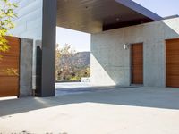 a gray concrete building with stairs and door at the top of the floor next to it is steps leading down to the doorway