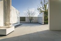 a patio area next to the pool, with a chair and planters nearby and a large stucco wall