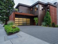 a large two story home with wood and glass garage doors on a residential street corner