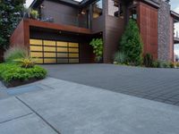 a large two story home with wood and glass garage doors on a residential street corner