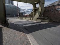 a view of a walkway crossing a bridge that runs over the road and there is a bus going underneath