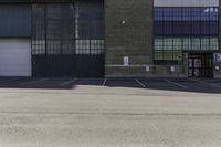 an empty parking lot with building in the background that reads warehouse - no cars required