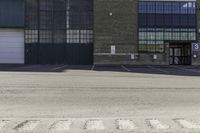 an empty parking lot with building in the background that reads warehouse - no cars required