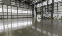 a large warehouse with lots of windows and concrete flooring on it's sides