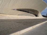 an outdoor walkway with steps that are made of stone and cement, leading to a white building