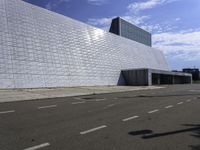 a large, modern white building with metal and glass facade, which is the most prominent symbol