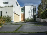 the front of a white two story house in the suburbs of los angeles with a sidewalk between two cars and an outdoor driveway