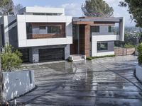 modern white residence in the city on a cloudy day near the hills with a paved driveway