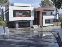 modern white residence in the city on a cloudy day near the hills with a paved driveway